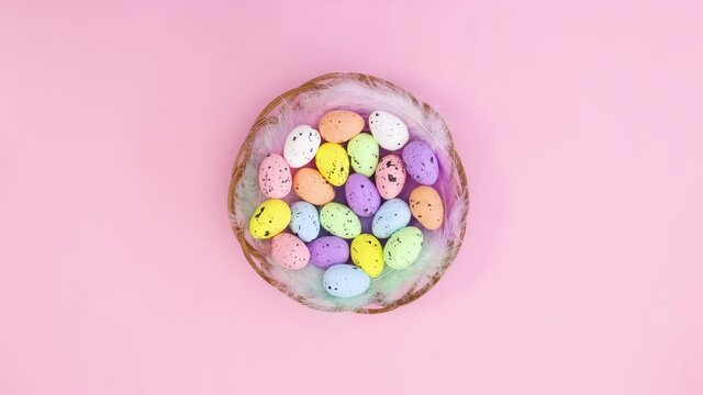 Wooden basket with eggs for Easter move in circle on pastel pink theme. Stop motion 