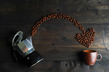 Italian coffee maker called mokapot and coffee beans on the "wooden" table