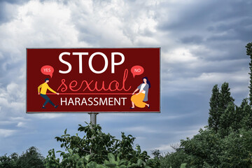 Advertising billboard with text STOP SEXUAL HARASSMENT on city street