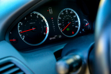 Close up view of the dashboard of a vehicle with speedometer and rpm display in focus