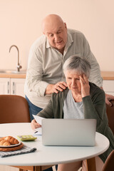 Stressed senior couple in debt at home