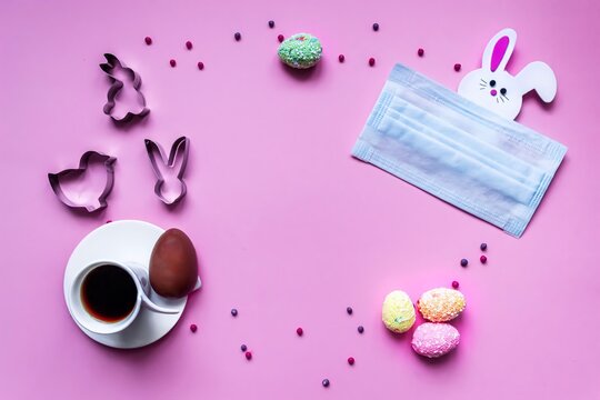 Flat lay of coronavirus quarantined easter composition. Easter eggs, coffee and handmade cookies on a pink background, frame, place for text. Bunny hides behind a medical mask