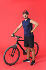 Fototapeta na wymiar Male cyclist with bicycle on color background
