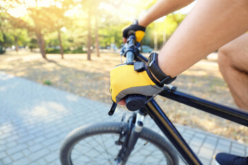Male cyclist riding bicycle outdoors, closeup