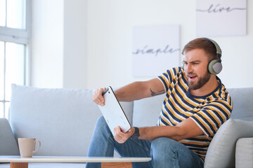Young man with tablet computer and headphones at home © Pixel-Shot