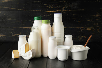 Different dairy products on dark wooden background