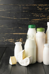 Different dairy products on dark wooden background