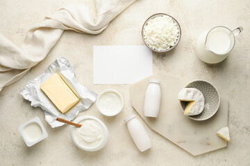 Different dairy products with blank card on light background
