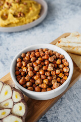 Leblebi Turkish delicacy of fried chickpeas, garlic and tortillas on compartmental dish, vertical food content, selective focus