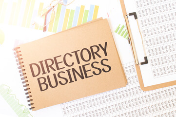 Business up graph on a sheet of craft colour Notepad with Directory Business sign. Notepad on desk with financial documentation