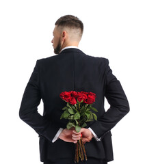 Handsome man with bouquet of beautiful flowers behind his back on white background