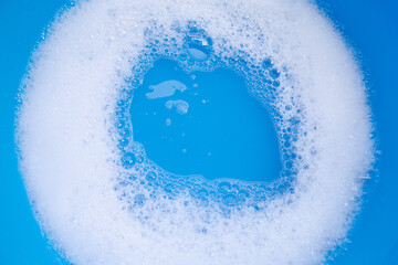 Detergent foam bubble on blue background.