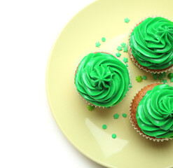 Plate with tasty cupcakes for St. Patrick's Day on white background