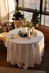 A festive day, a set table with New Year's decor. Candles and a cozy atmosphere. Christmas time. 