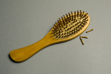 old wooden comb with dropped teeth on a gray background