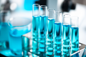 Chemistry laboratory glassware, science laboratory research and development concept, flask, beaker, and test tubes with blue liquid water sample test, scientific test tubes equipment