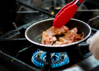 fresh fried bacon in a pan, Chef cooking in the kitchen