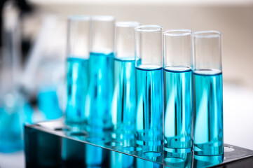 Chemistry laboratory glassware, science laboratory research and development concept, flask, beaker, and test tubes with blue liquid water sample test, scientific test tubes equipment