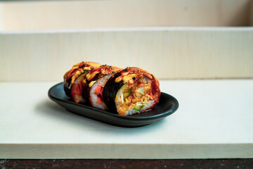 Korean food, gimbap or kimbap in a plate on a wooden background.