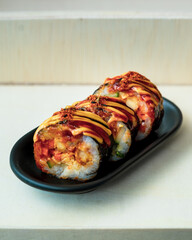 Korean food, gimbap or kimbap in a plate on a wooden background.