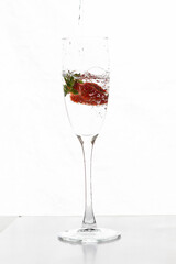 Filling up the champagne glass with strawberry isolated on a white background copy space