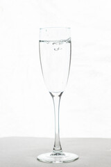 Filling up the champagne glass water  isolated on a white background