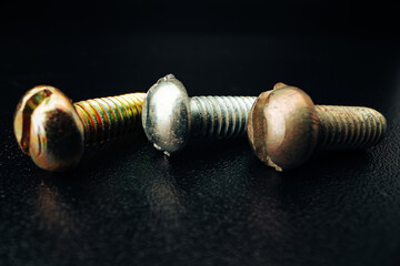 Iron screw bolts on black background close up