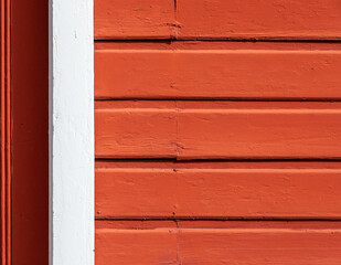 Fototapeta premium An old red exterior wooden siding wall with a white frame element at left, a useful image for copy space.