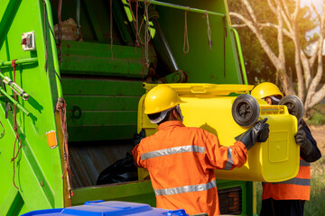 Garbage man working together on emptying dustbins for trash removal.
