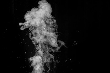 Curly white steam rising up and splashing water scattering in different directions isolated on a black background. Evaporation of liquid and condensation. Can be used as background, design element