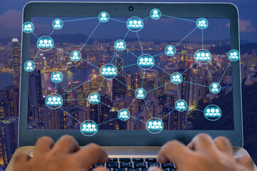 People using laptop to connect with other person with wireless networking diagram over cityscape at night that represent the internet communication in worldwild.
