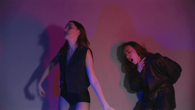 Footage of dancing drunk girls in room with red and blue light