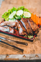 Smoked Barbecue Pork Spare Ribs with Sauce on a cutting board, selective focus
