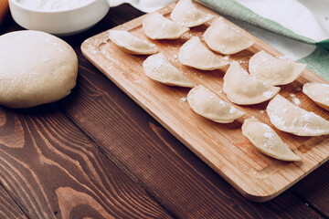 Raw stuffed russian dumplings on wooden board