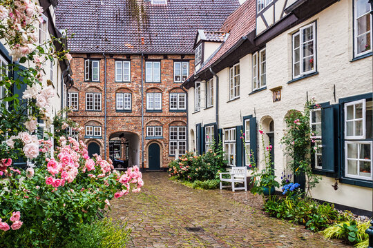 Beautiful cozy courtyard with old houses and flowers in the street of old town Lubeck, Germany