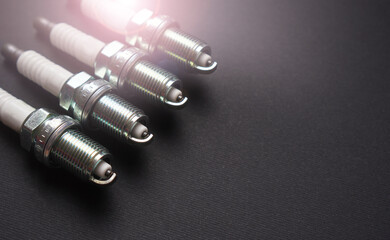New automobile spark plugs on a dark background with copy space