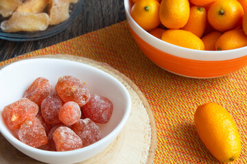 Food photos of fresh and dried kumquat. A pile of tropical citrus fruits in a plate on a wooden table. Vitamin C. Antioxidants. Dietary products. Proper nutrition. Top view.