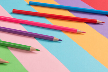 Color pencils array isolated on colour paper background