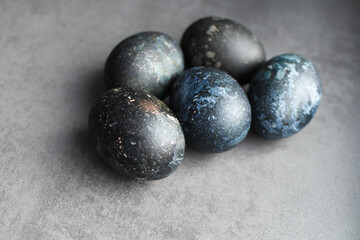 Dark Easter eggs dyed with natural dyes. Dyed eggs in a dark blue tone. Easter festive background, open card, eggs close-up. Table setting for the Easter holiday. Christ the Risen Easter holiday.