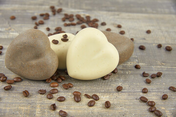 Fototapeta na wymiar Fragrant natural handmade soap in the shape of a heart and coffee beans on a countertop.