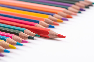 One pencil standing out from the group of other pencil on white background