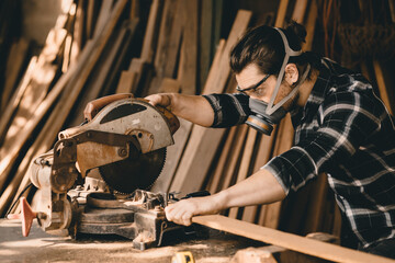 Fototapeta na wymiar Carpenter man using Electric Wood Cutter machine with protection safety equipments in wood workshop