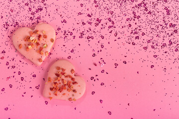 Valentine heart cookies dry strawberries on pink background with confetti