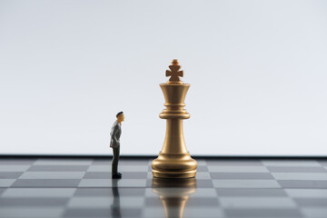 Business and Competition Concept. Businessman miniature figure standing on chessboard with chess pieces