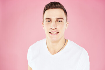 Cheerful handsome man in white t-shirt emotions pink isolated background