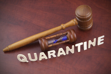 Wooden gavel with hourglass and word quarantine. Lockdown and quarantine time concept.