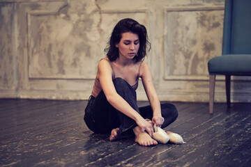 modern dancer in jeans puts on pointe shoes, classical and modern style concept in art.