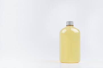 Transparent plastic low thick bottle with orange drink, cooking oil or cosmetic produce with silver cap mockup on white background, template, copy space.