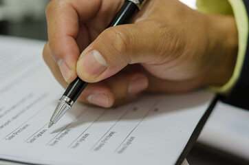 Hand with pen to sign the document