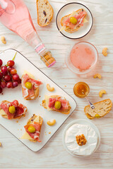 Flat lay of Appetizers and open sandwiches with Italian antipasti, camembert, Parma ham and rose wine